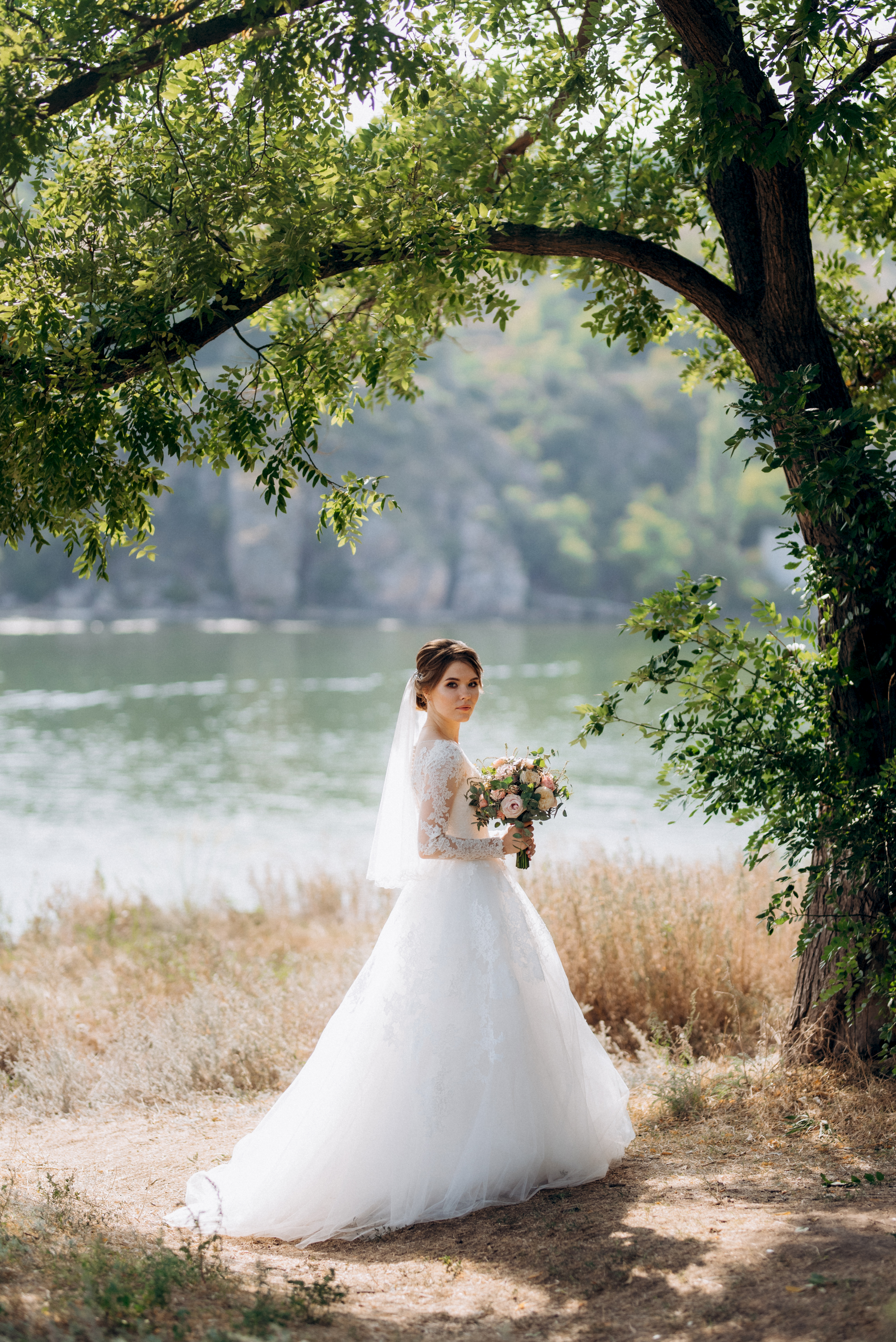 bride blonde girl with a bouquet in the forest in the sunset light